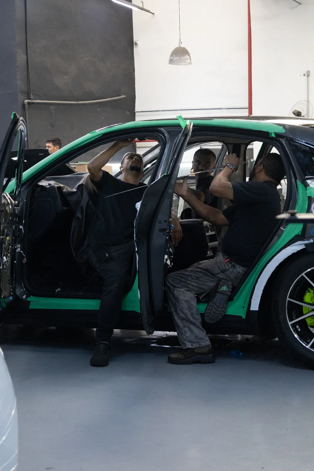 Equipe da Stark instalando a blindagem nas portas de um carro